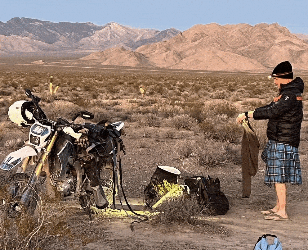 Man wearing a kilt with a motorbike in the desert